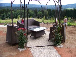 a patio with a couch and a table with flowers at Gästehaus Rachelblick in Frauenau