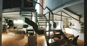 a person standing in a living room with a spiral staircase at Casa Ruiz in Ayerbe