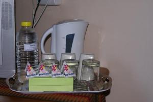 a tray with drinking glasses and a bottle of water at Airport Inn Bed and Breakfast in Kempton Park