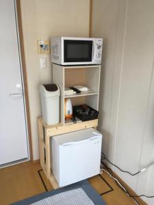 高千穂町にあるゲストハウスいわとの電子レンジ(洗濯機付きの棚の上に座る)