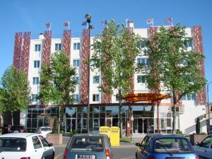 a large white building with cars parked in front of it at Logis Hotels Grand Hotel d'Orléans in Albi