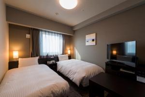 Tempat tidur dalam kamar di Hotel Route-Inn Grand Tokyo Asakusabashi