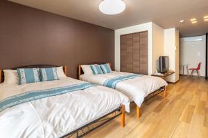 Un pat sau paturi într-o cameră la Tino Asuka