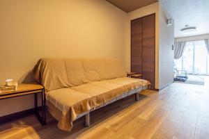 1 dormitorio con 1 cama y suelo de madera en Tino Asuka en Osaka