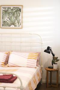 a bedroom with a white bed with a lamp and a plant at Island Cottages in Nelly Bay