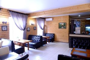 a restaurant with chairs and tables and a fireplace at Pride Hotel in Taraz