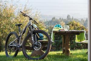 una bicicleta estacionada junto a una mesa con un casco en Ferienwohnungen Theresienhof, en Ledenitzen