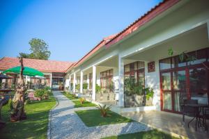 an exterior view of a building with a garden at Tree Roots Retreat in Rayong