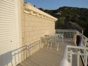 eine Terrasse mit Tisch und Stühlen auf einem Deck in der Unterkunft Apartments Marija in Slano