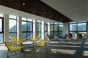a group of chairs and tables in a room with windows at Joy Trip Hotel & Spa Nha Trang in Nha Trang