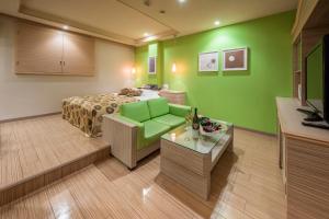 宇都宮市にあるレステイ 宇都宮（大人専用）の緑の壁、ベッド付きのベッドルーム1室