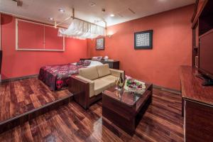 a red room with a bed and a couch at Restay Utsunomiya (Adult Only) in Utsunomiya