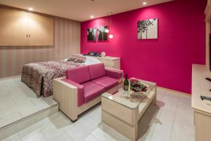um quarto rosa com uma cama e um sofá rosa em Restay Utsunomiya (Adult Only) em Utsunomiya