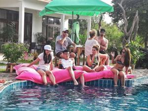 a group of people sitting on rafts in a swimming pool at Tree Roots Retreat in Rayong