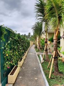 un sendero ajardinado con plantas y palmeras en RC ubud villa en Ubud