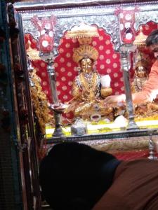 una estatua de un dios sentado en un santuario en Kashi Annapurna Guest House, en Varanasi