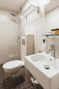 Baño blanco con aseo y lavamanos en Hotel Point, en Estocolmo