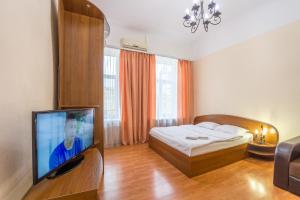 DayFlat Apartments Maidan Area في كييف: غرفة نوم بسرير وتلفزيون بشاشة مسطحة