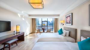 una camera d'albergo con due letti e una televisione di SSAW Boutique Hotel Ningbo CBD a Ningbo