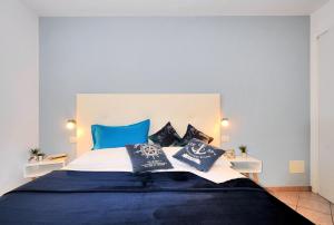 ein Schlafzimmer mit einem großen Bett und blauen Kissen in der Unterkunft Residence Corallo in Caorle