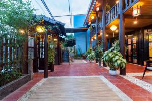 a walkway in a building with a bunch of plants at An Bang Stilt House Villa in Hoi An