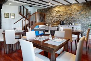 a dining room with a wooden table and white chairs at Katrapona in Getaria