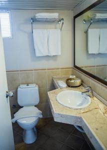 ein Badezimmer mit einem Waschbecken, einem WC und einem Spiegel in der Unterkunft Halıcı Hotel Marmaris in Marmaris