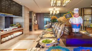 una linea a buffet con piatti di cucina in un ristorante di SSAW Boutique Hotel Ningbo CBD a Ningbo