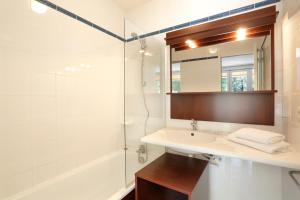 La salle de bains est pourvue d'un lavabo, d'une douche et d'un miroir. dans l'établissement Vacancéole - Le Domaine de Chames - Pont d'Arc, à Vallon-Pont-dʼArc