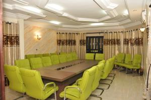 una sala de conferencias con una mesa larga y sillas verdes en Diamond hotel en Cotonú