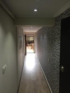 a hallway with a brick wall and a wooden floor at Araz Apart in Bursa