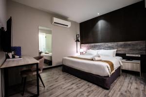 Habitación de hotel con cama grande y escritorio. en The Leverage Business hotel (Skudai) en Johor Bahru