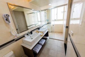 ein Bad mit einem Waschbecken, einem Spiegel und einer Dusche in der Unterkunft ManMan House Ruifang in Ruifang