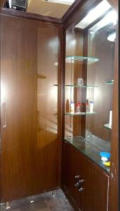 a wooden cabinet with glass shelves in a kitchen at Feel Like Home in Visakhapatnam