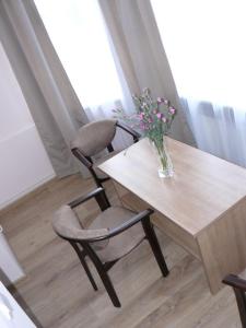 a table and chairs with a vase of flowers on it at Victoria in Międzyzdroje