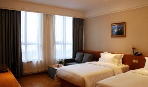 Postel nebo postele na pokoji v ubytování Linjiang International Cruise Hotel Baoyang Road