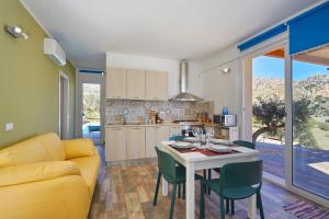 Una cocina y una sala de estar con un sofá amarillo y una mesa. en Villa Montemar, en Balata di Baida