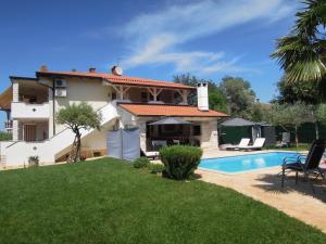 a villa with a swimming pool and a house at Holiday Home Villa Ivan in Umag