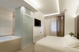 una camera bianca con letto e TV di Hotel Polo a Rimini