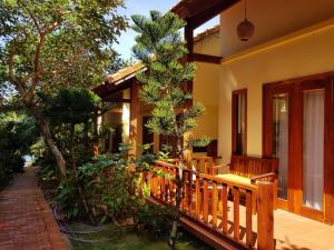 a house with a porch and a tree at Free Beach Resort in Phú Quốc