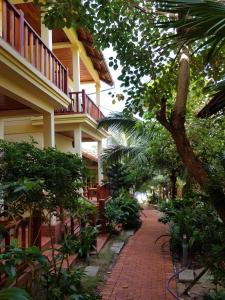 a brick walkway in front of a building with trees at Free Beach Resort in Phú Quốc