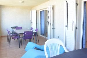 サリ・ソランザラにあるPALMERAIE 325のリビングルーム(テーブル、紫の椅子付)
