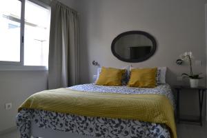 サンタクルス・デ・テネリフェにあるGFS Loftのベッドルーム1室(黄色い枕と鏡付きのベッド1台付)