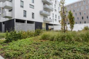 リールにあるWelkeys - Alain de Lille Apartmentの庭園を正面に望むアパートメントビル