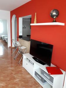 プエルト・デル・カルメンにあるapartamento MAKTUBの赤い壁のリビングルーム(テレビ付)