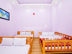 2 camas en una habitación con paredes blancas en Gia Khanh Hotel, en Da Lat