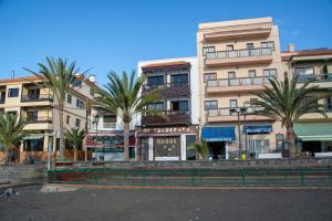 een gebouw met palmbomen ervoor bij Apartamento Casanova 1A in La Playa Calera