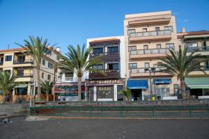 a building with palm trees in front of it at Apartamento Casanova 1A in La Playa Calera