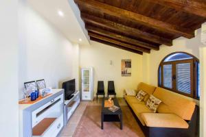 een woonkamer met een bank en een tv bij Casa Torre Mudéjar in Toledo