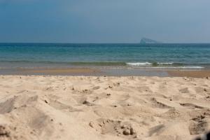 a sandy beach with the ocean in the background at Hotel El Palmeral in Benidorm